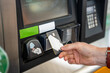 Close up view of man hand pays for fuel with a credit card on terminal of self-service filling station in Europe