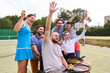 © Robert Kneschke - Inclusive friends taking a group selfie after a fun tennis match with a person using a wheelchair