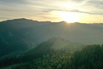 Wall Mural - Aerial view of beautiful mountain landscape with green trees at sunrise