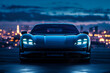 Low Angle View of Blue Sports Car at Night. Front low angle view of a blue sports car at night with city lights.
