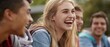 © Maureen - A group of young people enjoy laughter and conversation on an outdoor bench,