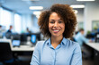 Smiling woman with curly hair in a busy modern office
