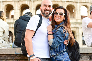 Wall Mural - Happy  Beautiful Tourists  couple traveling at Rome, Italy, taking a selfie portrait in front   of Colosseum.Visiting Italy - man and woman enjoying weekend vacation - Happy lifestyle concept 