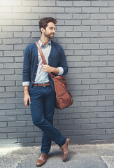 Canvas Print - Happy, businessman and leather bag for fashion, style and comfort outdoors with a wall background. Formal model, smile and clothes for working, career or job opportunity with outside brick backdrop