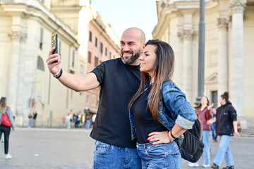 Wall Mural - Happy  Beautiful Tourists  couple traveling at Rome, Italy, taking a selfie portrait Visiting Italy - man and woman enjoying weekend vacation - Happy lifestyle concept 