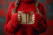 Woman in Red Sweater Holding a Craft Paper Wrapped Gift with a Red Yarn Bow, Big Sale