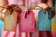 Hands Presenting Vintage Textured Tags with Rustic Twine and Heart Detail on Pink Background, Big Sale