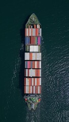 Wall Mural - A container ship moves steadily through the ocean, carrying stacked containers