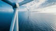 An aerial perspective of a wind farm in the ocean, showcasing rows of tall wind turbines on the sustainable energy site