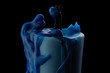 Burnt out blue candle in melted wax on black background