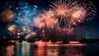  Colorful fireworks burst in the dark sky above the water, creating bright streaks of light and showers of sparks. The reflection of the fireworks glimmers on the calm surface of the water below.
