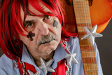 Fototapeta Tulipany - Portrait of an old crazy musician with a guitar