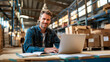 © Dina Photo Stories - Issuing orders from the warehouse. Young smiling man groups the order. man with a laptop and boxes on the background of the warehouse. Order picker. Delivery, shipping department