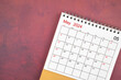 May 2024 desk calendar on red background.