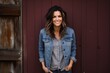 © Markus Schröder - Portrait of a glad woman in her 40s sporting a rugged denim jacket in rustic wooden wall
