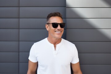 Poster - Portrait of a grinning man in his 40s wearing a trendy sunglasses isolated on modern minimalist interior