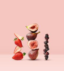 Wall Mural - Creative layout made of strawberry, figs and blackberry on the pink background. Food concept. Macro concept.