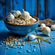 garlic in a bowl on a blue wooden background. close up