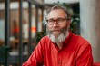 © Visual Horizon Art - Portrait of mature businessman freelancer startup, bearded man smiling and looking at camera, business owner working inside modern office building wearing red shirt and, Generative AI