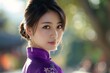 Evoke beauty and grace in a detailed depiction of a young Chinese woman seen from the rear Emphasize her big eyes, double eyelids, and high nose bridge with a round face shape Dress her in purple atti