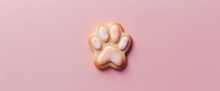 A Single Dog Paw Cookie On A Solid Pink Background. The Puppy-shaped Cookies Have Pastel-colored Icing That Forms The Shape Of Cat Paws And Is Dusted With White Powder To Look Like Fur