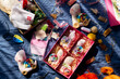 Top view of soft handmade fabric snail toys and various sewing supplies in gift box