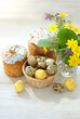 Easter cakes (Paska, Kulich), chickens toys and eggs with flowers on white wooden table. Easter holiday background. Festive composition for spring season.