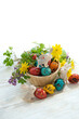 Easter holiday. cute Easter bunny and colorful eggs with flowers on table, white background. festive composition for spring season. Ostara sabbat. spring equinox