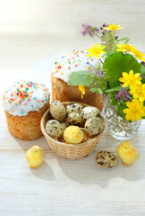 Wall Mural - Easter cakes (Paska, Kulich), chickens toys and eggs with flowers on white wooden table. Easter holiday background. Festive composition for spring season.