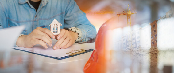 A civil engineer shows a model of a house.