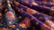 A luxurious spread of Indian silk in deep violet, patterned with golden lotus flowers. 