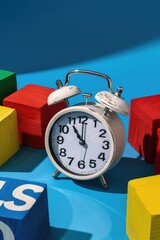 Poster - A clock sitting on a table next to blocks. Can be used for concepts of time management