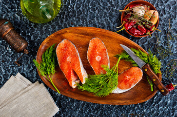 Poster - fresh salmon steak raw fish prepared for cooking. Top view on black slate table.