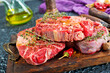 Top view of raw meat pieces placed on wooden tray sprinkled with salt
