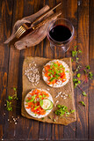 Fototapeta Tulipany - Tasty bruschetta with salmon. Salmon toast with cream cheese, arugula and sunflower seeds