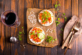 Fototapeta Tulipany - Tasty bruschetta with salmon. Salmon toast with cream cheese, arugula and sunflower seeds