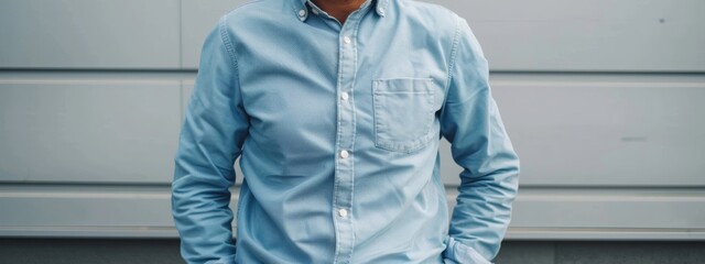 Confident Young Man in Blue Shirt Posing with Hands in Pockets Outdoors