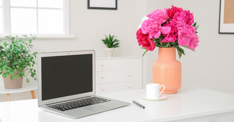 Wall Mural - Vase with beautiful peony flowers and laptop on table in room