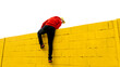 © ADDICTIVE STOCK - Climbing a bright yellow wall under a clear sky