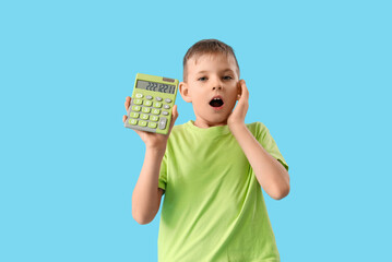 Wall Mural - Shocked little boy with calculator on blue background