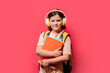 © ADDICTIVE STOCK - Schoolgirl with headphones and books on pink background