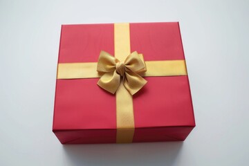 Wall Mural - A red gift box with a shiny gold bow. Perfect for holiday and celebration concepts