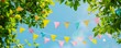 Colorful banner with colorful bunting flags and green tree leaves on a blue sky background Generative AI