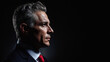 © remake - Side profile a focused and professional man in a suit and tie, set against a dark background. Lighting highlights his facial features and the contours of formal attire.