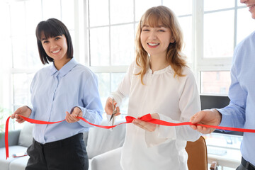 Poster - Business woman cutting red ribbon in office