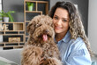 Young woman with cute poodle at home, closeup
