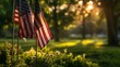 A row of American flags proudly displayed among green shrubbery, bathed in the warm sunlight of a clear day..