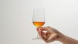 Side view of a hand elegantly holding a whisky glass against a clean white background.