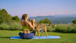 Lady in yellow top is having trouble doing yoga because her dog distracts her