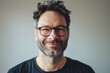 © Iigo - Portrait of a handsome man with beard and glasses on grey background